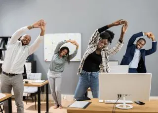 Équipe pratiquant des mouvements au bureau